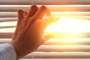 Hand an Fensterjalousie